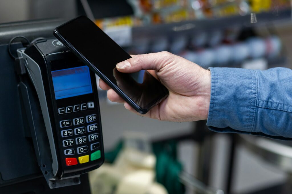 Man using smartphone for mobile payment at checkout